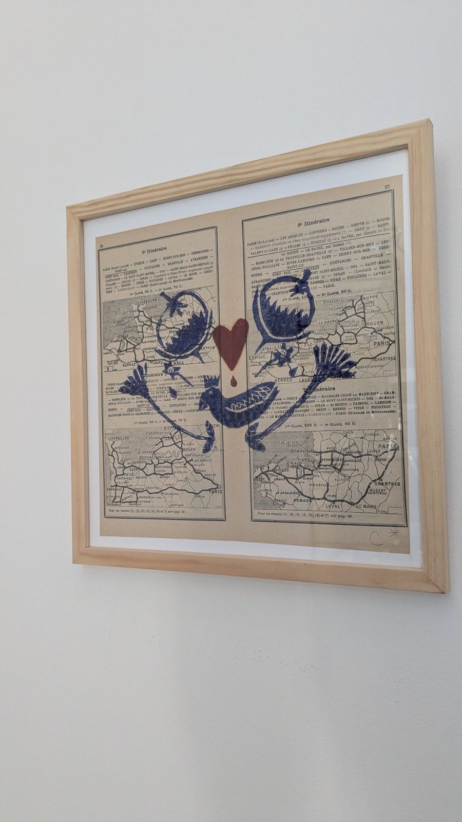 Linogravure de deux oiseaux et d'un cœur, imprimée sur une page de dictionnaire ancien
